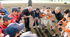 Cal Ripken huddles with young baseball players. 