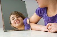 Photo of girl looking in the mirror and smiling