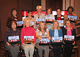 11 women from the Charleston, West Virginia Champions training class pose holding their speaker kits.
