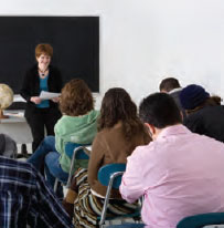 Photo - Students sit in their desks as the teacher instructs the class