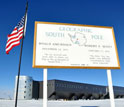 Image of a sign at the geographic South Pole located at 90 degrees south latitude.