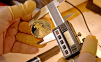 Photo shows a coin being measured with a caliper.