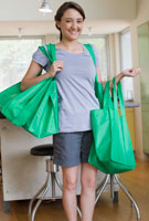teen holding "green" grocery bags