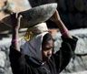 Date: 02/17/2000 Description: A child laborer carries cement at a construction site near Dharmsala, India. © AP Image