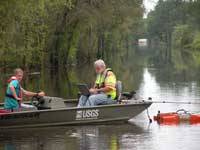 Scientists measuring streamflow on a flooded road.