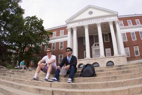 Two men sitting on steps of college library