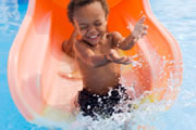 A toddler coming down a water slide