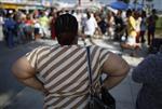 An overweight woman watches a street performer at Venice Beach in Los Angeles, California, May 11, 2012. Picture taken May 11, 2012. REUTERS/David McNew