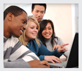 A group of teens woking in a computer together