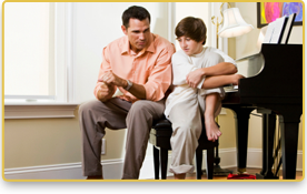 Un niño y su padre hablan sentados junto al piano