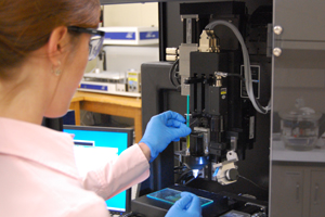A photograph of a scientist running a gradient coating experiment in the laboratory.