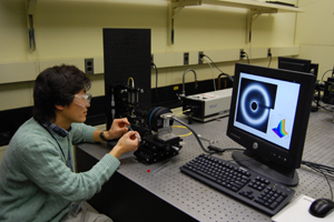 A photographo of a scientist examining thermal wrinkling. 