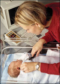 Photo: A woman checking a newborn's hearing