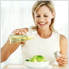Woman Pouring Oil on Salad