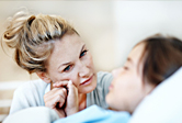 A mother comforts her sick daughter. 