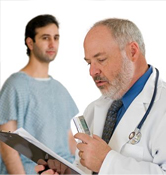 Patient in the background as doctor records notes.