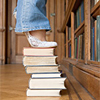 woman standing on top of a stack of books