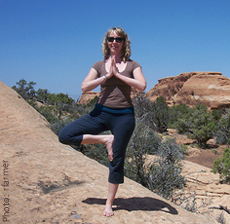 A woman standing in a yoga pose (tree pose)