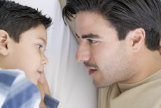 Photograph of a boy and a man talking