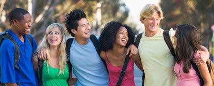 Photograph of teens walking arm in arm together.