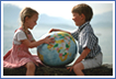Two children examine a globe