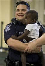 A U.S. Customs and Border Protection officer waits in the processing area with one of the orphans arriving from Haiti in Sanford, FL.