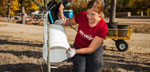 Photo of woman watering a newly-planted tree at Coldwater Spring