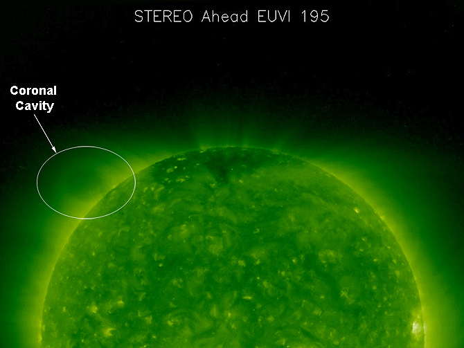 The faint oval hovering above the upper left limb of the sun in this picture is known as a coronal cavity.
