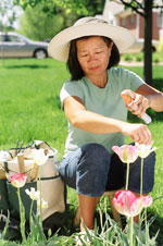 Photo: Woman in garden using insect repellent