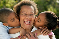 Photo: Grandchildren kissing grandmother's cheeks