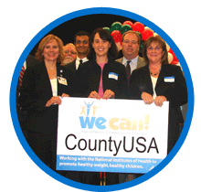 Image of adults holding a sign that says We Can County USA