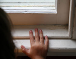 la mano de una muchacha en el alféizar de una ventana vieja