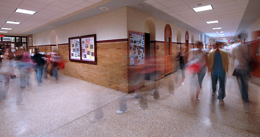 Blurry action shot of students walking down a busy hallway