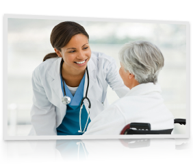 A smiling doctor leans down to talk to a patient in a wheelchair.