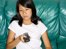 teen girl with a tv remote in her hand