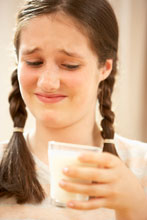 Lactose intolerant girl look at a glass of milk