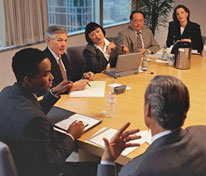 People in business outfit having a round table meeting.