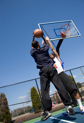 Photo of two students playing basketball.