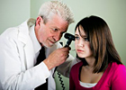 Doctor looking in girl's ear