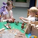 One of the Special Participating Youth (SPYs) plays at the Knight table with a Treehouse Museum visitor.