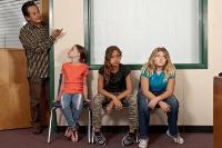 Students sit outside the principal's office