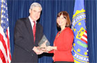 Amy Fleischauer accepts the award from FBI Director Mueller.