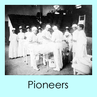 Three surgeons standing in an operating room performing surgery with several nurses and attendants observing.  Courtesy Moorland-Spingarn Research Center, Howard University