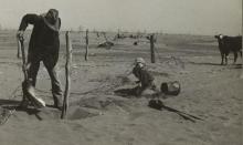 Plains farmer raises fence to prevent it from disappearing under sand.farmer