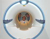 a photo of three researchers looking through an MRI machine.