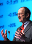 a photo of a man lecturing at a podium.