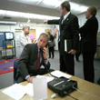 Director of Communications Dan Bartlett points to news footage of the World Trade Center Towers burning, September 11, 2001, as President George W. Bush gathers information about the attacks while at the from Emma E. Booker Elementary School in Sarasota, Florida.