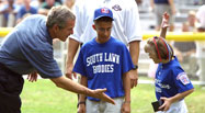 President George W. Bush congratulates members of the Waynesboro, Virginia Little League Challenger Division Sand Gnats after their Tee Ball on the South Lawn game, September 22, 2002.