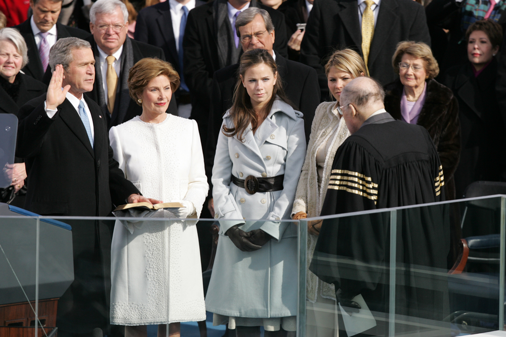 With his left hand resting on a family Bible, President George W. Bush takes the oath of office to serve a second term as 43rd President of the United States, January 20, 2005, during a ceremony at the U.S. Capitol. Laura Bush, Barbara Bush, and Jenna Bush listen as Chief Justice William H. Rehnquist administers the oath.   (P44290-391)