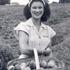 Woman holding a basket of peaches in a farm field